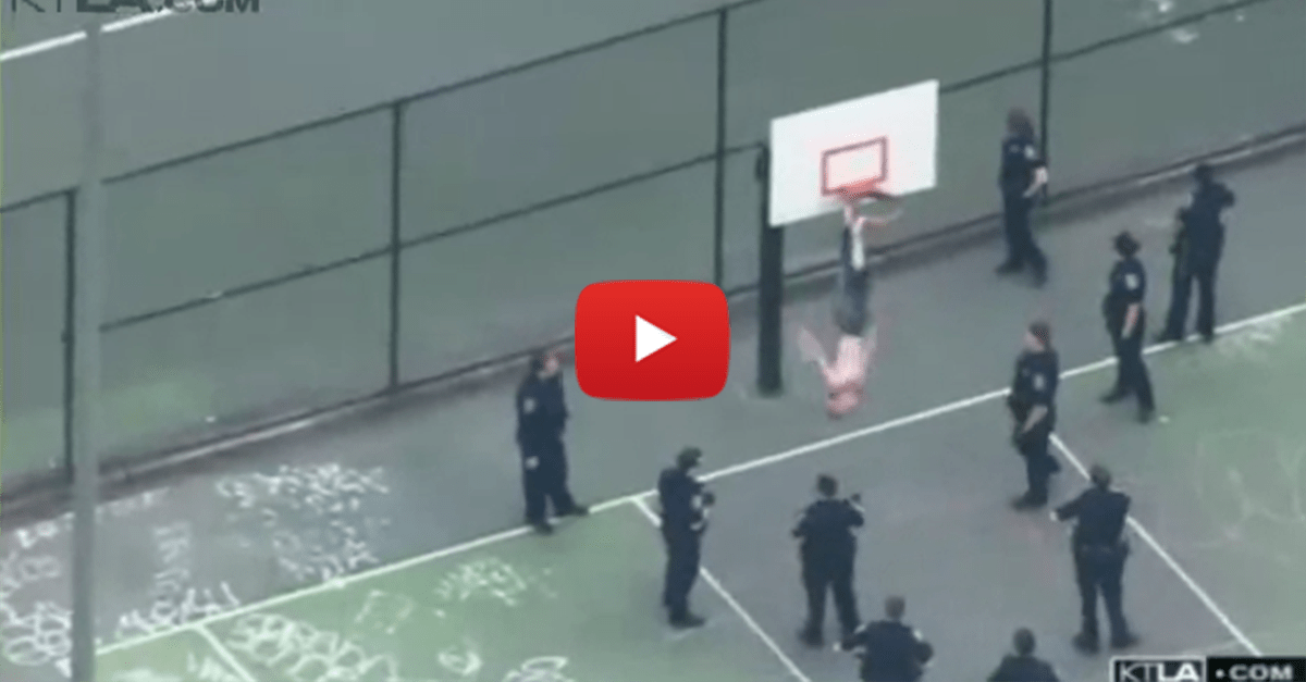 Shirtless man gets stuck upside-down in a basketball hoop, police and firemen rescue him