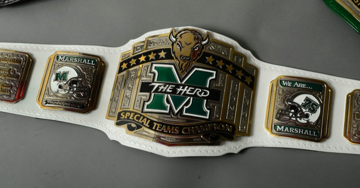 Marshall football has new team trophies in the form of wrestling title belts