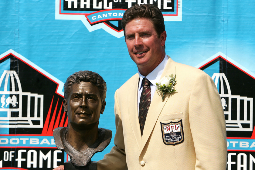 Dan Marino poses next to his Pro Football Hall of Fame bust