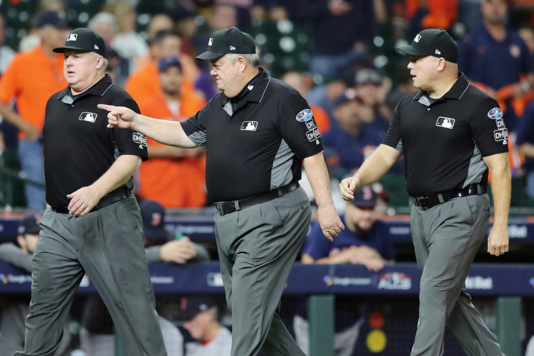 Umpires walk on the field before Game Five of the American League Championship Series in 2018