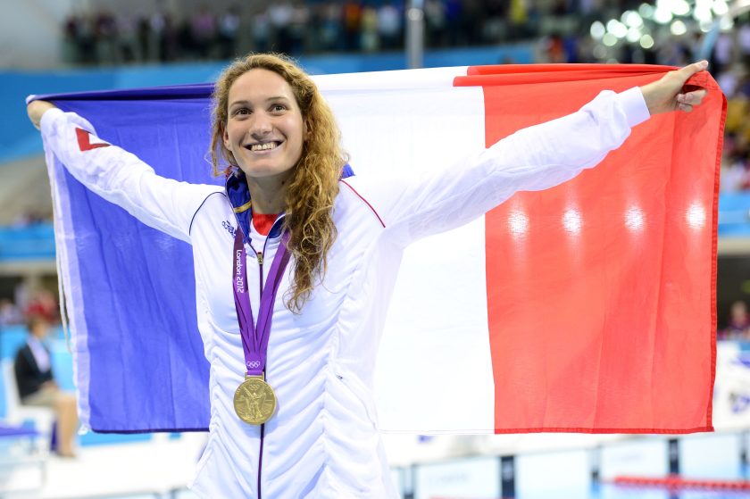 France's gold medalist Camille Muffat poses with a flag on the podium after winning the women's 400m freestyle swimming event at the London 2012 Olympic Games.