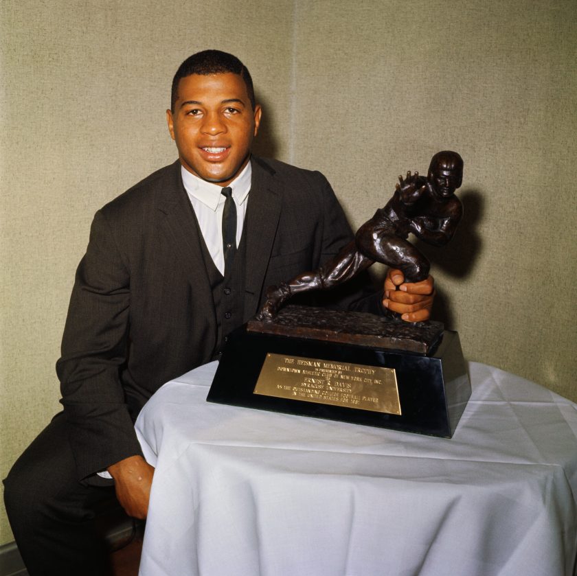 Syracuse University halfback Ernie Davis holds the 1961 Heisman Trophy.
