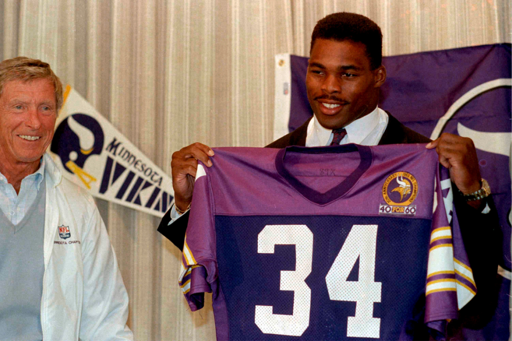 Herschel Walker holds up a Vikings jersey after being traded to Minnesota.