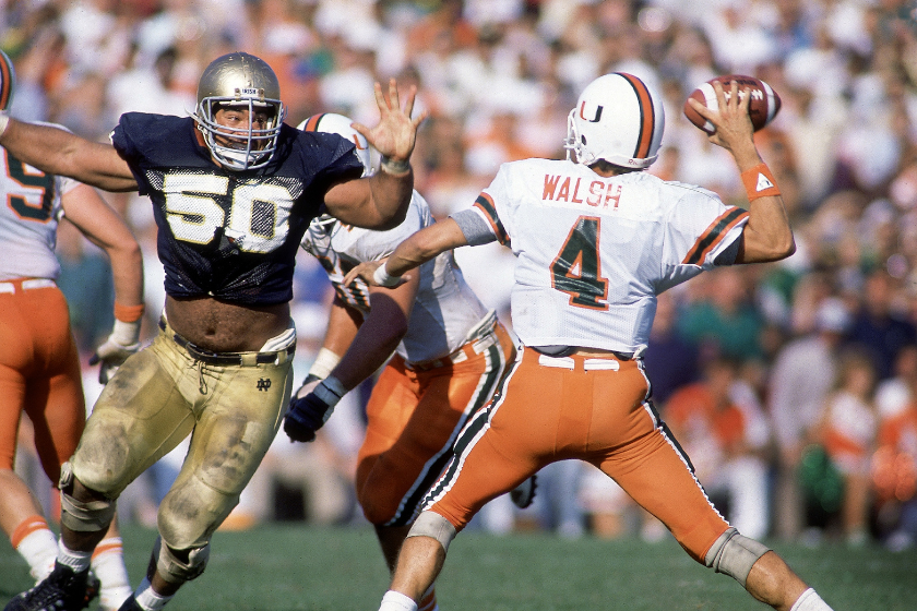 Miami QB Steve Walsh (4) in action, making pass under pressure vs Notre Dame Chris Zorich (50) at Notre Dame Stadium