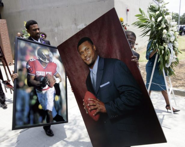 Portraits of former NFL quarterback Steve McNair are carried away from his funeral service.
