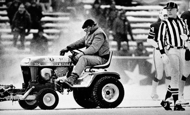 Mark Henderson clears snow as referee Bob Frederic watches during the Snow Plow game.