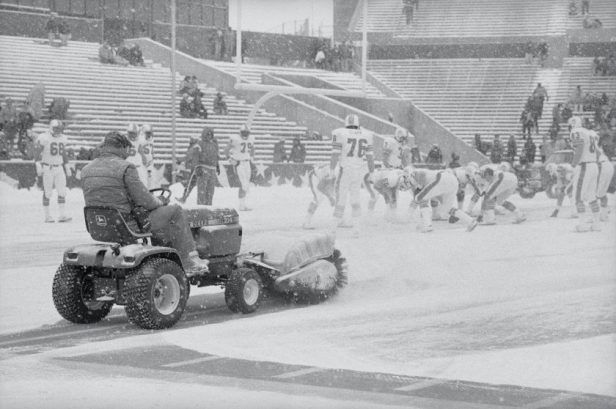 A man operating a snow plow clears snow before a field goal in the "Snow Plow" game.