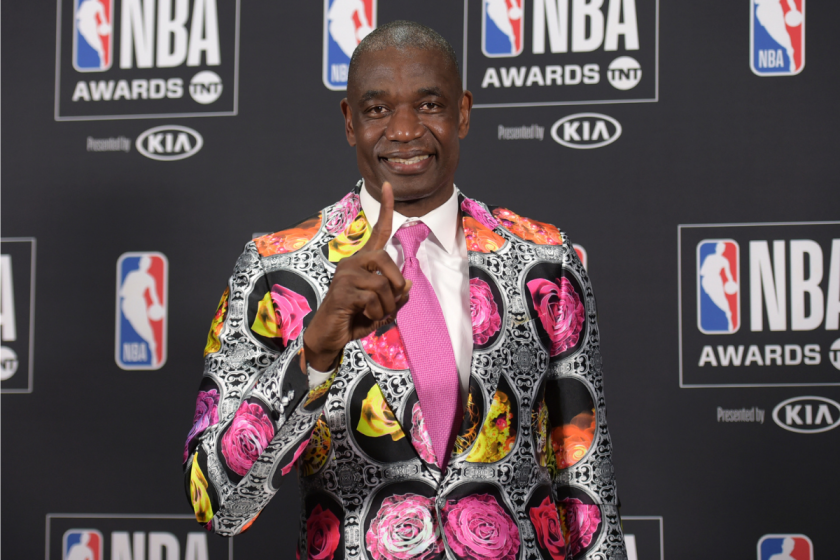 Dikembe Mutombo holds his pointer finger up.