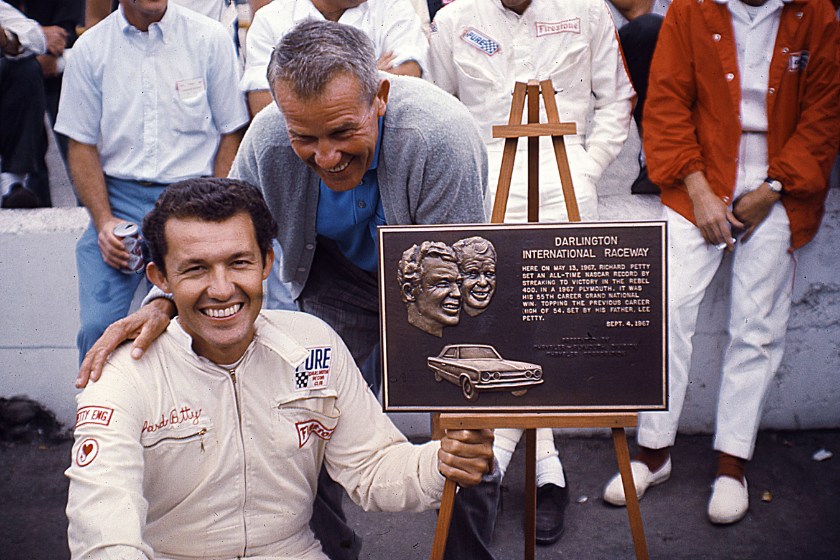 Richard Petty and his father Lee Petty pose with a plaque given to Richard by Darlington Raceway. The plaque commemorates the younger Petty's 55th career NASCAR Cup win in the Rebel 400 held in May at Darlington