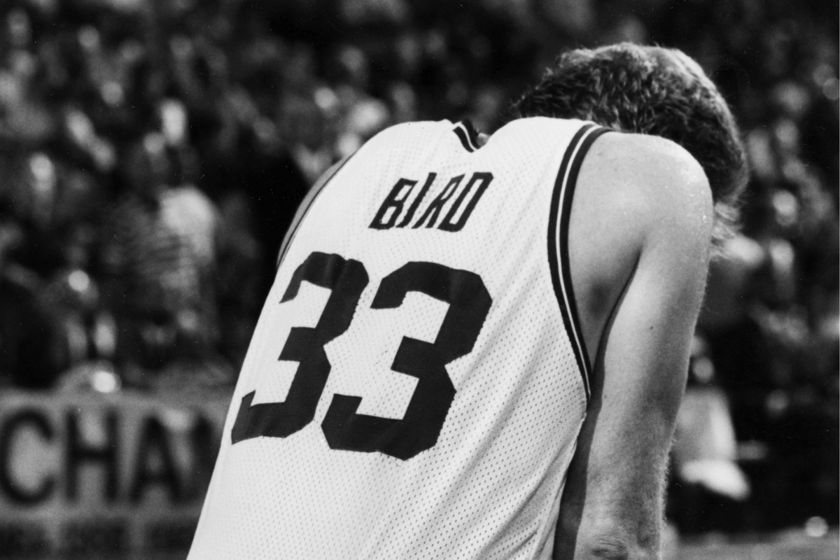 Larry Bird kneels after hitting his head on the parquet floor during the 1991 NBA Playoffs