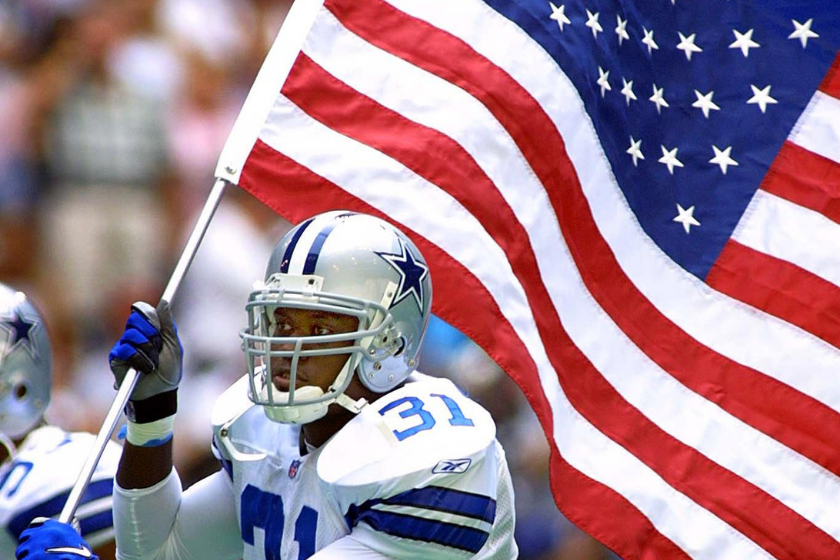 Dallas Cowboys DB runs the American flag onto the field following the September 11, 2001 attacks.