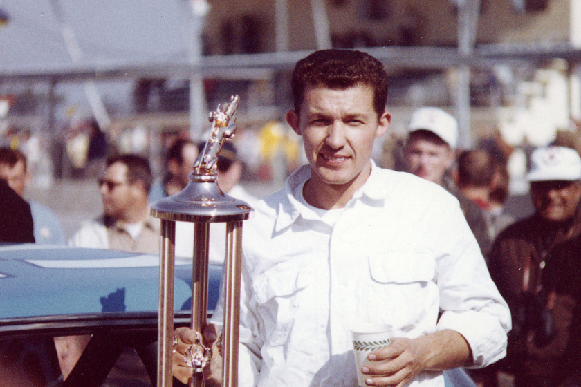 Richard Petty holds his trophy in victory lane at Daytona International Speedway after winning the 1964 Daytona 500