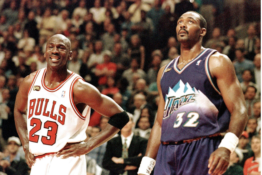 Michael Jordan smiles while standing next to Karl Malone of the Utah Jazz