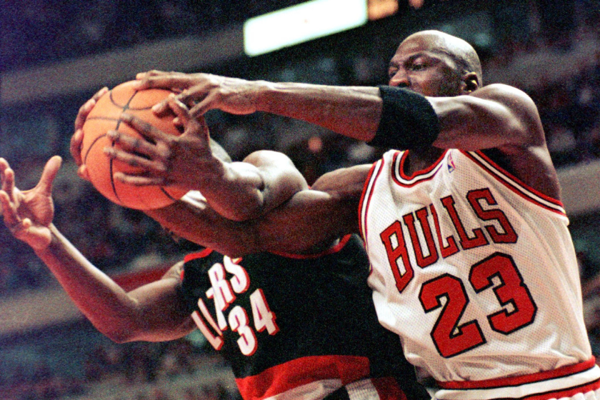 Michael Jordan reaches for a ball being grabbed by an opponent