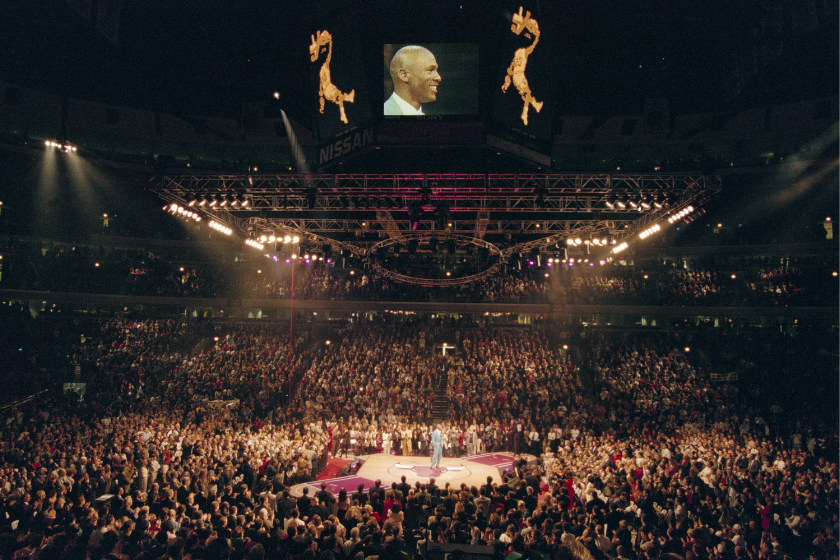 michael jordan stands in the middle of a crowd during his retirement ceremony