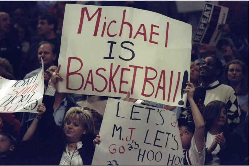  Fans of Michael Jordan #23 of the Chicago Bulls hold up signs during a game