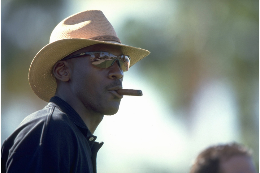 michael jordan smokes a cigar while wearing sunglasses and a cowboy hat