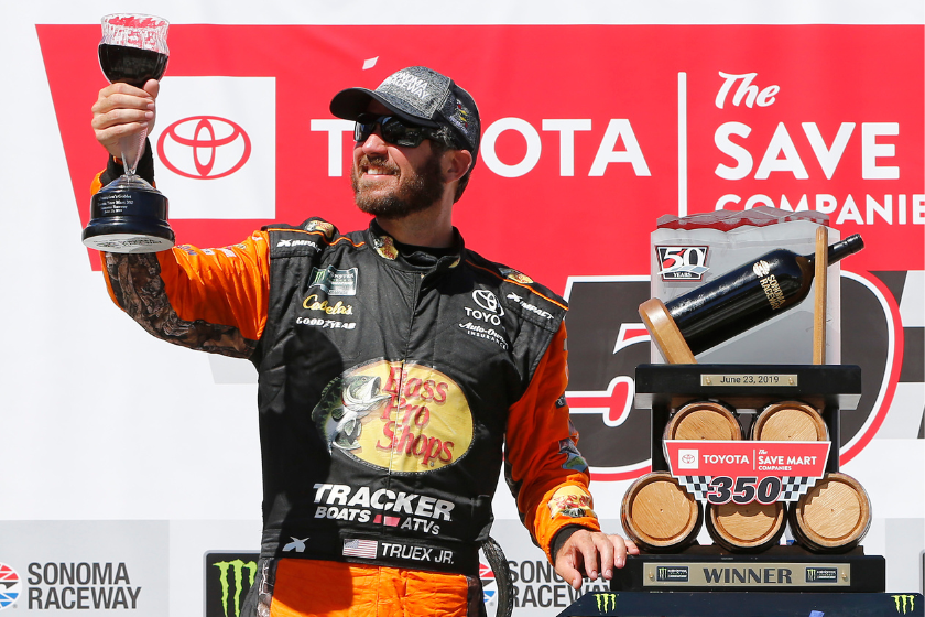 Martin Truex Jr. poses with the trophy in Victory Lane after winning the 2019 ToyotaSave Mart 350 at Sonoma Raceway on June 23