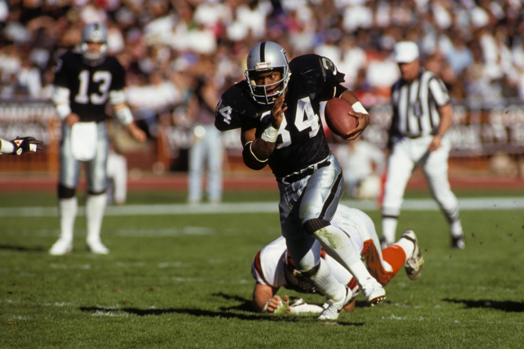 Bo Jackson rushes with the ball during an Oakland Raiders game.