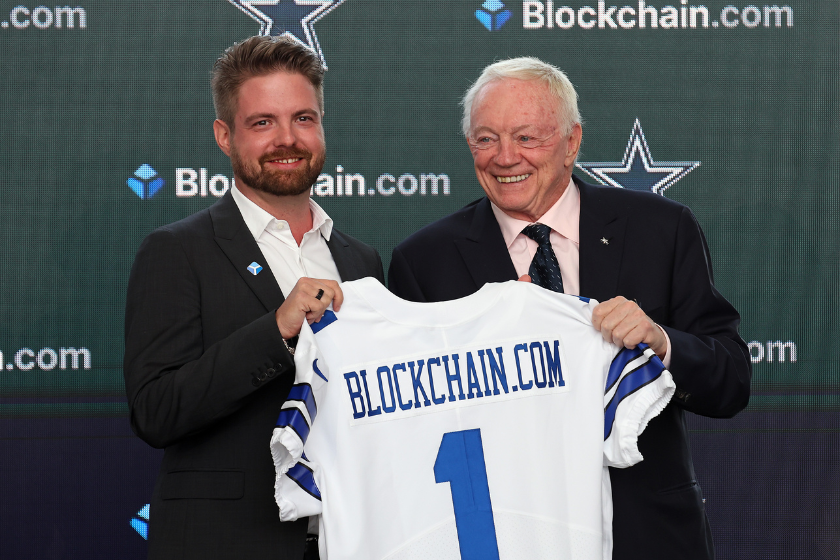 Dallas Cowboys owner Jerry Jones (R) presents Blockchain.com CEO Peter Smith with a jersey after announcing a historic partnership at The Star in Frisco