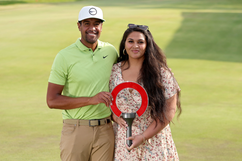 Tony Finau of the United States and wife Alayna Finau pose with the trophy on the 18th green after Finau won the Rocket Mortgage Classic at Detroit Golf Club 
