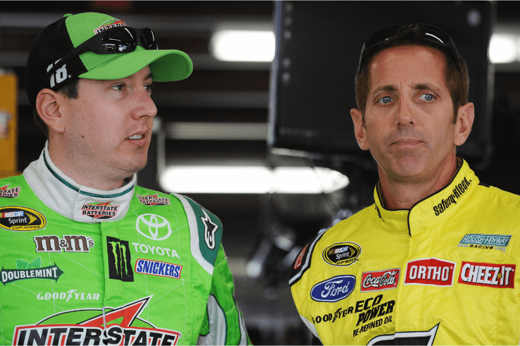 Kyle Busch and Greg Biffle stand in the garage area during practice for the 2015 5-Hour Energy 301 at New Hampshire Motor Speedway