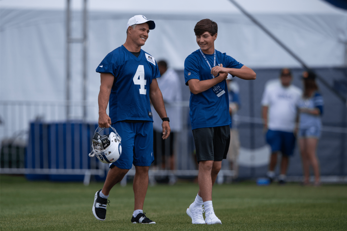 Adam Vinatieri walks onto the field with his son AJ Vinatieri before the Indianapolis Colts training camp practice on July 26, 2019.