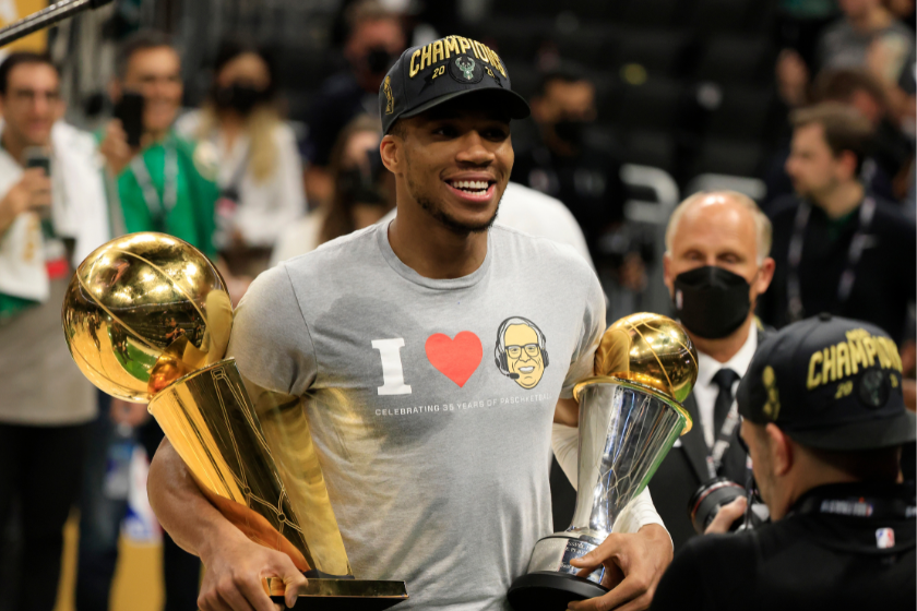 : Giannis Antetokounmpo #34 of the Milwaukee Bucks holds the Bill Russell NBA Finals MVP Award and the Larry O'Brien Championship Trophy after defeating the Phoenix Suns in Game Six to win the 2021 NBA Finals