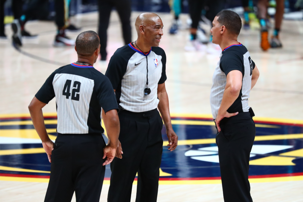 Three NBA refs discuss a call.