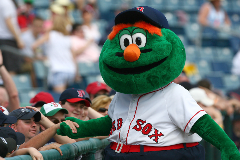 Wally the Green Monster shakes the hand of a fan before a Boston Red Sox game.