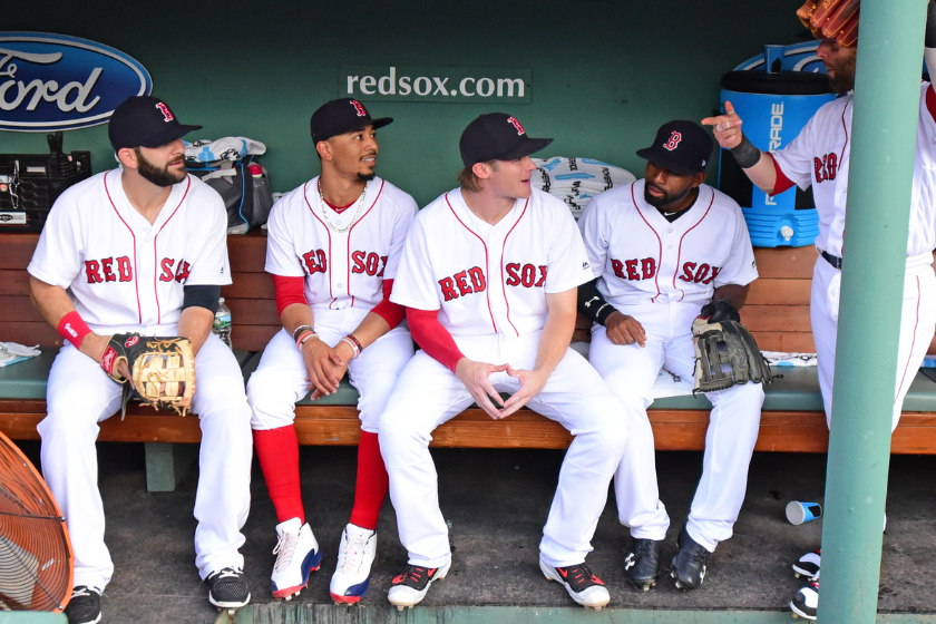 Mitch Moreland #18, Mookie Betts #50, Josh Rutledge #32, Jackie Bradley Jr. #19 and Dustin Pedroia #15 of the Boston Red Sox talk on the bench before a game against the Philadelphia Phillies at Fenway Park