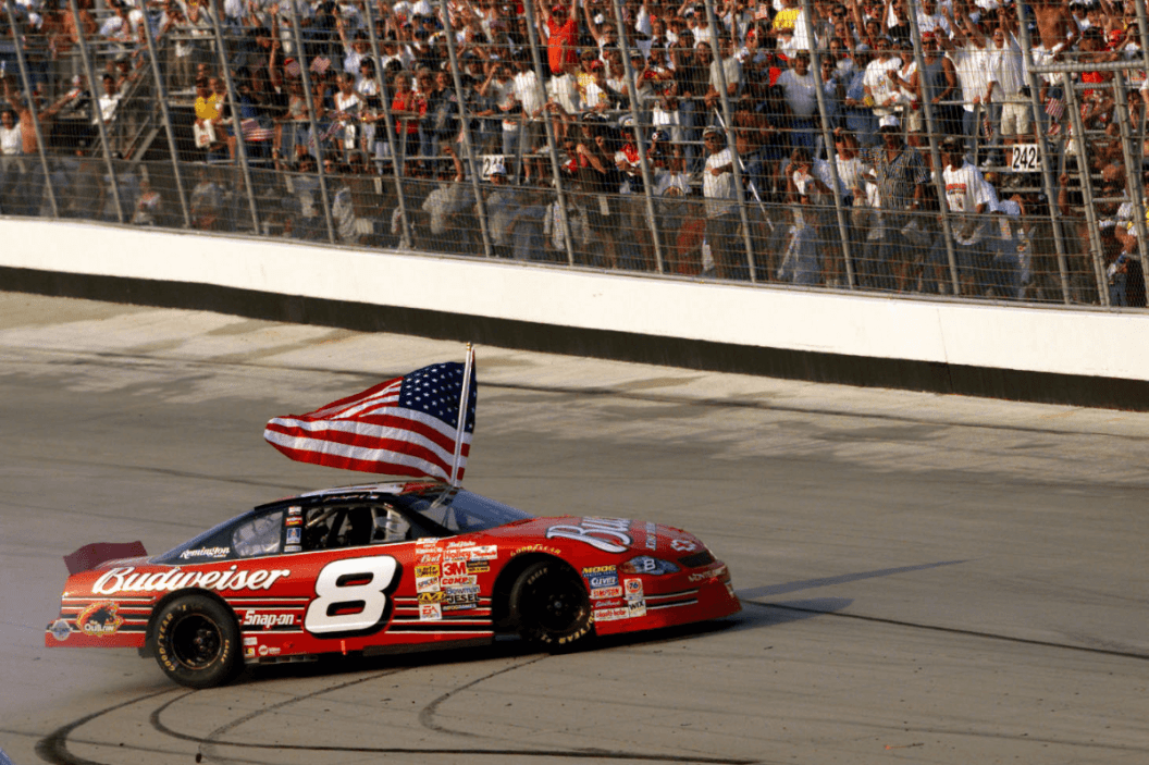 Dale Earnhardt Jr. carries American flag as he burns the tires of his No. 8 Chevrolet following his win in the MBNA-Cal Ripken Jr. 400 at Dover International Speedway on Sept. 23, 2001