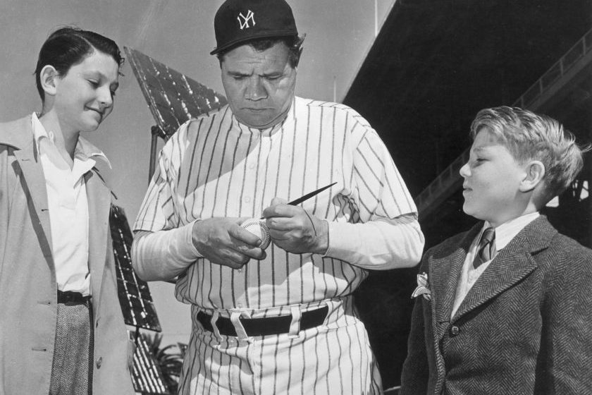 Babe Rith signs an autograph for two fans in 1945.