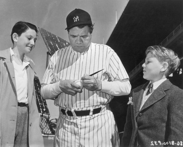Babe Rith signs an autograph for two fans in 1945.