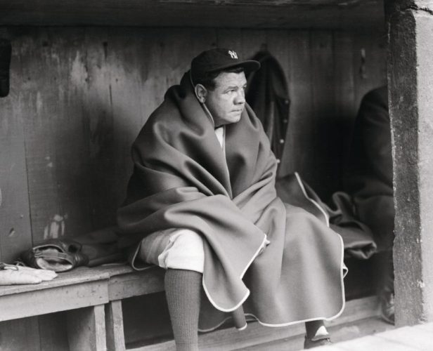 Babe Ruth wears a blanket in the dugout