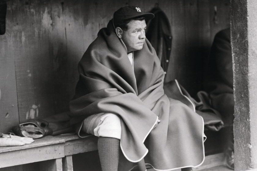 Babe Ruth wears a blanket in the dugout