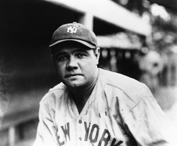 Babe Ruth poses for a photo by the dugout.