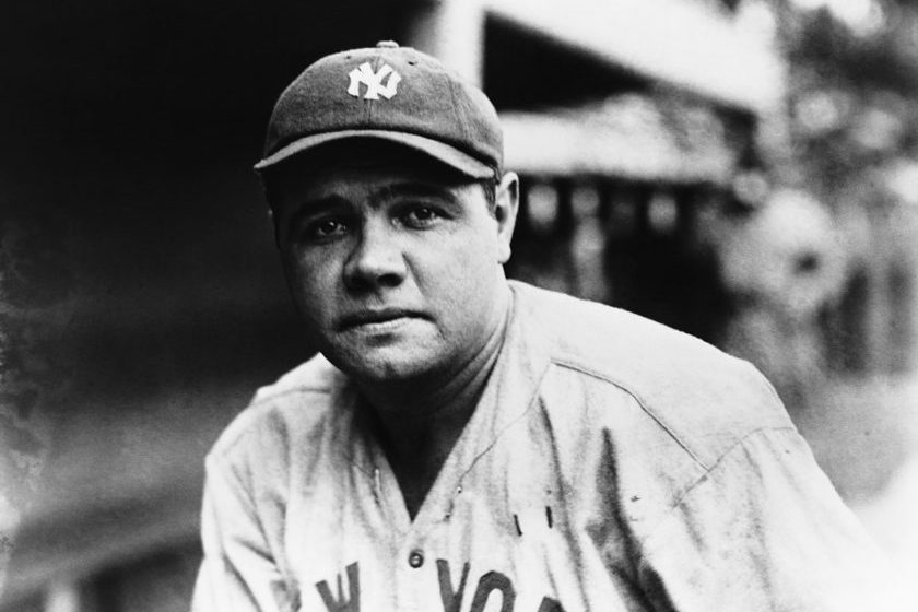 Babe Ruth poses for a photo by the dugout.