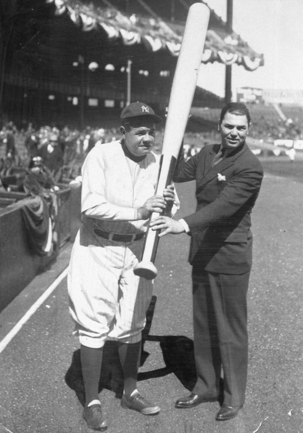 Babe Ruth holds a large bat in 1929.