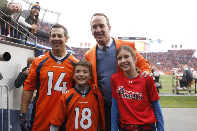 Brandon Stokely, Peyton Manning, Marshall Manning, and Mosley Manning pose for photos during a Ring of Honor induction ceremony.