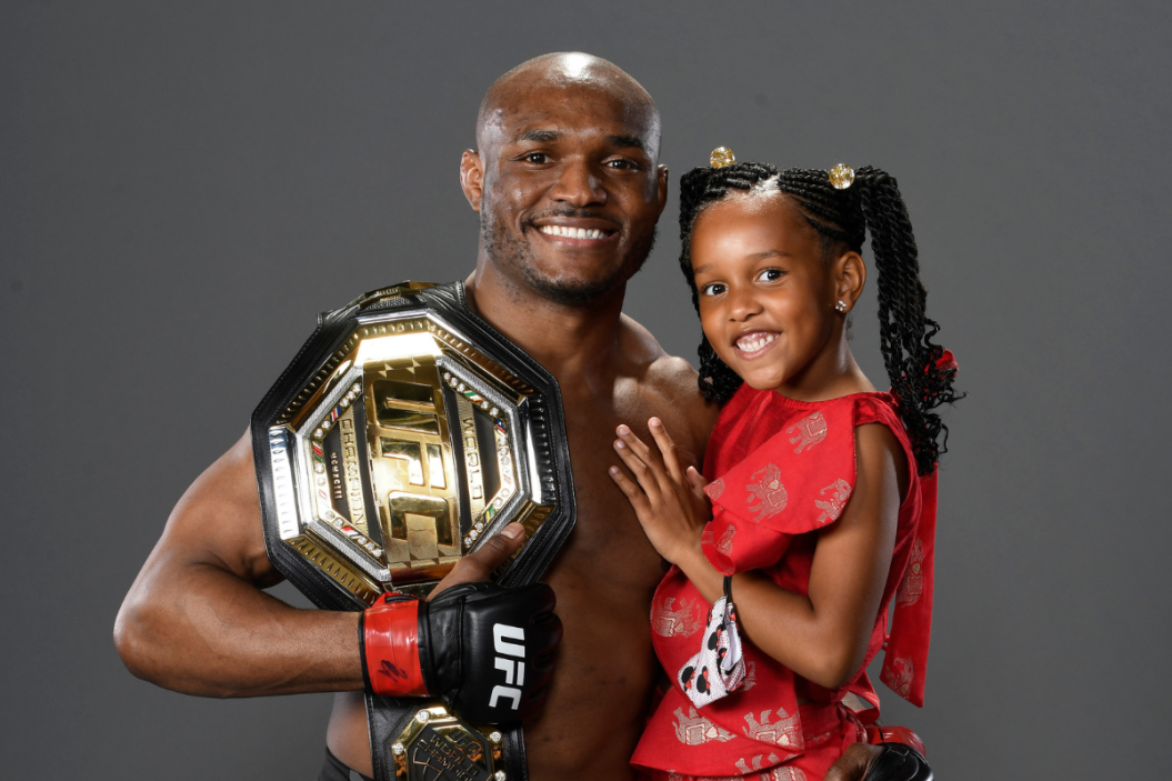 Kamaru Usman of Nigeria poses with his daughter Samirah for a post fight portrait backstage during the UFC 261 event