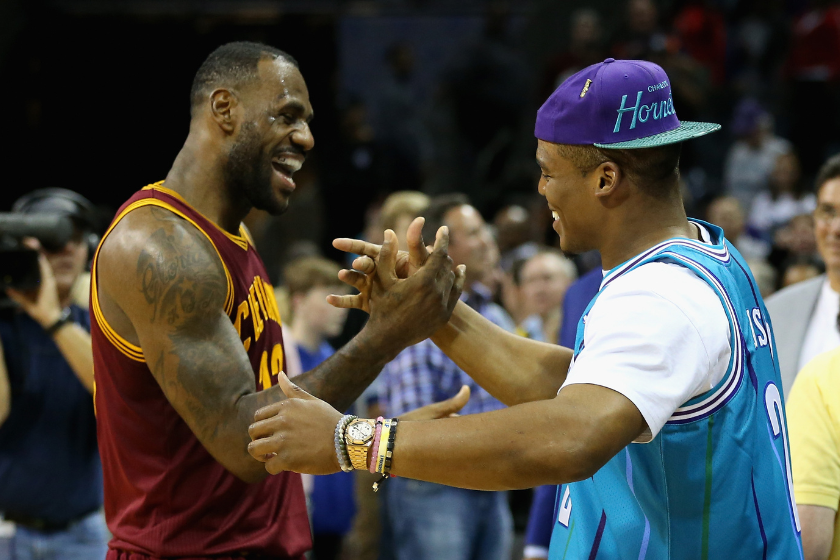  LeBron James #23 of the Cleveland Cavaliers talks to Cam Newton, quarterback of the Carolina Panthers after the Cavaliers defeated the Hornets 95-90 at Time Warner Cable Arena