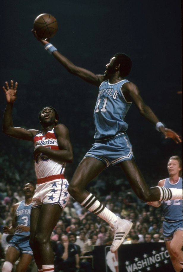 A Buffalo Braves player drives in for a layup against the Washington Bullets.