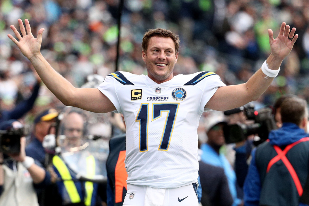Philip Rivers #17 celebrates a pick six by Desmond King #20 of the Los Angeles Chargers in the fourth quarter against the Seattle Seahawks at CenturyLink Field