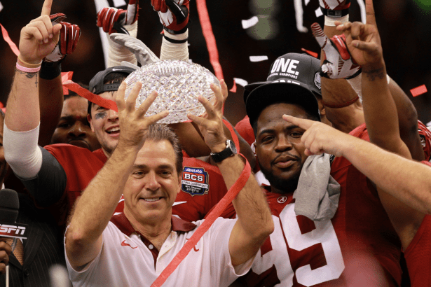 Nick Saban holds the 2012 BCS National Championship trophy.