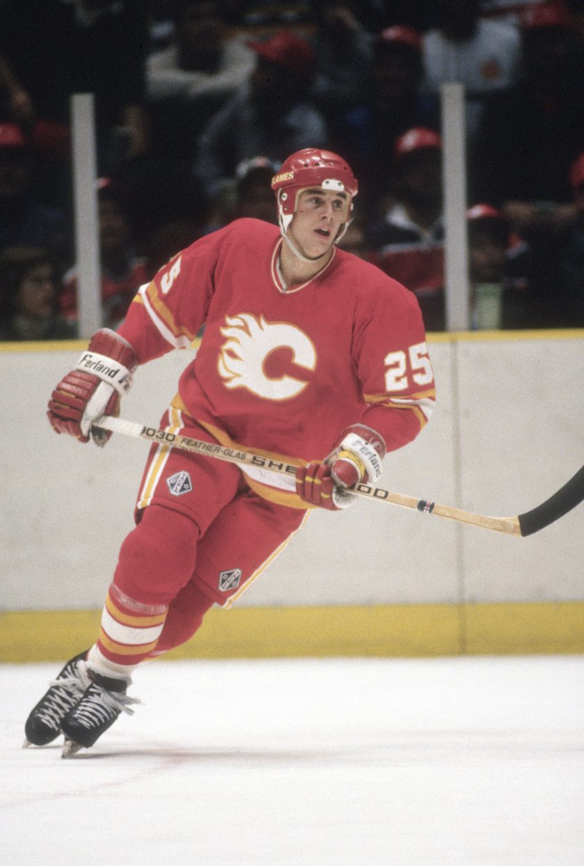 A Calgary Flames player skates with his stick.