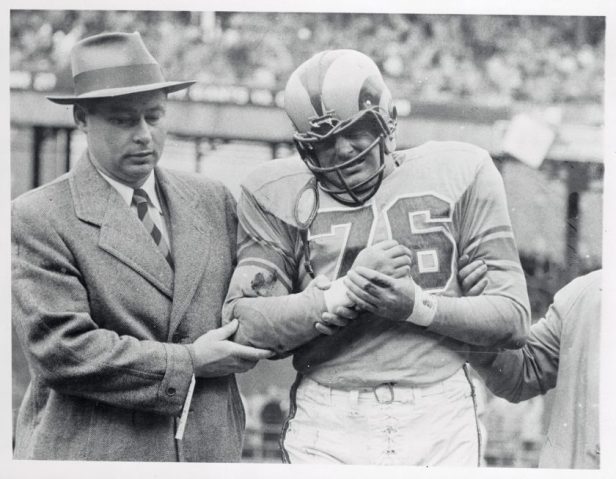 Harland Svare is helped off the field during a Rams game.