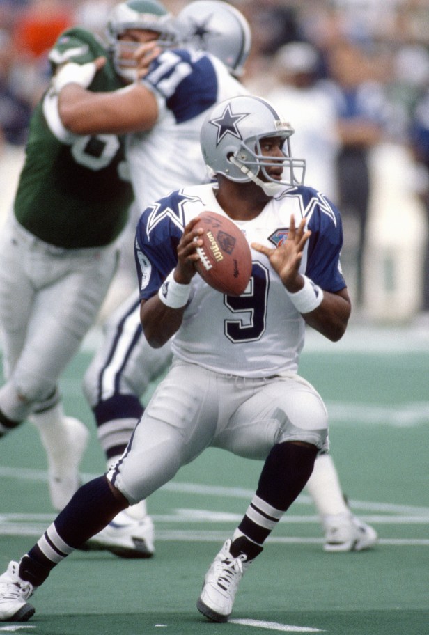 A Dallas Cowboys quarterback drops back to pass during a game.