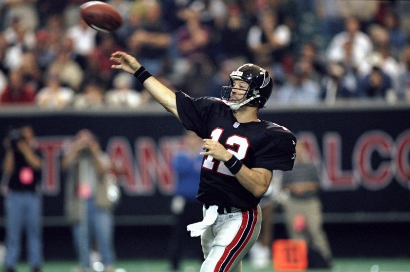 An Atlanta Falcons quarterback throws a pass in a black jersey.