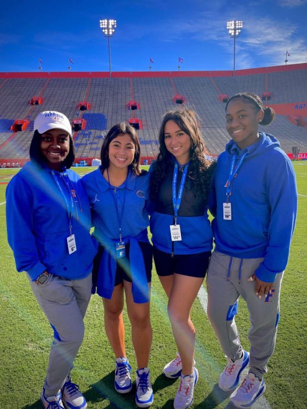Jacquelyn Pacheco and fellow interns take a picture on field at Ben Hill Griffin Stadium.
